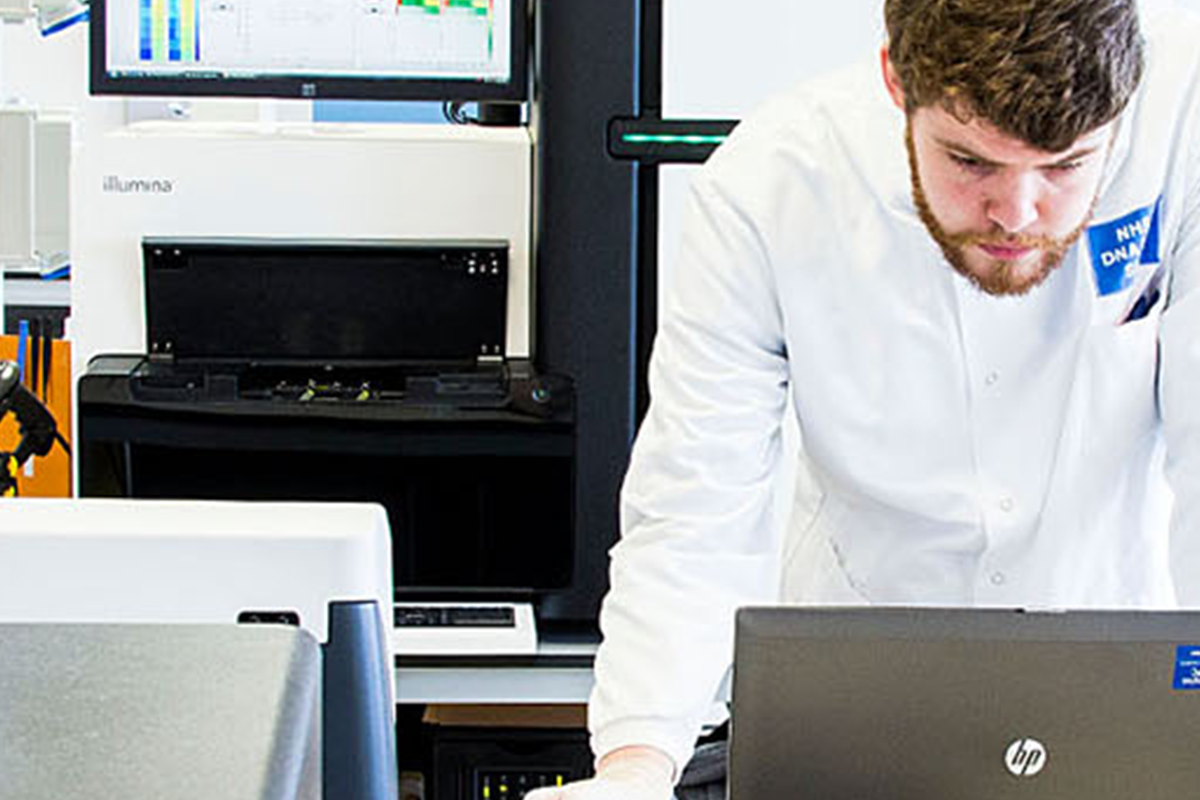 Man standing at a laptop in a laboratory.