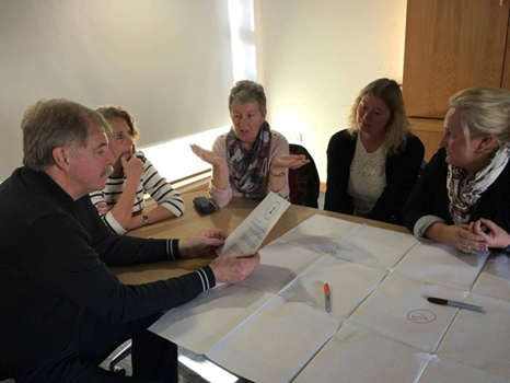 A group of patients holding a discussion, whilst sitting around a table