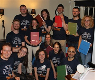 The Manchester Centre for Genomic Medicine Lab team, holding books containing a printed copy of the human genome